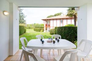 a white table and chairs on a patio at Côte Basque in Urrugne