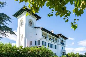 a white building with trees in front of it at Côte Basque in Urrugne