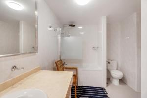a bathroom with a sink and a tub and a toilet at Casa Papaya in El Médano +24 photos