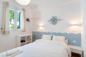 a bedroom with a white bed with a blue headboard at Livadia Seaside Studios 6 in Parikia
