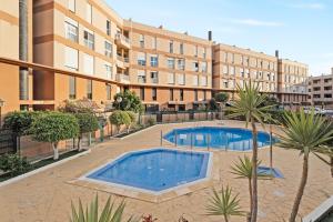 two swimming pools in a courtyard with a building at Casa Papaya in El Médano
