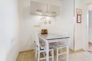 a white kitchen with a table and chairs at Ferienwohnung oberhalb vom Hafen 2 in Sassnitz