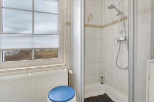 a bathroom with a shower and a blue toilet at Ferienwohnung oberhalb vom Hafen 2 in Sassnitz +21 photos