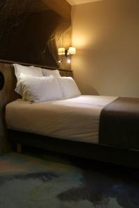 a bedroom with a bed and a lamp at Le Saint Aubert in Le Mont Saint Michel