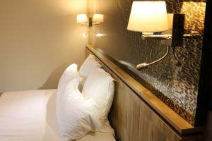 a hotel room with a bed with two pillows at Le Saint Aubert in Le Mont Saint Michel