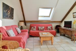 a living room with two red couches and a table at Gîte Yveco in Châteauneuf