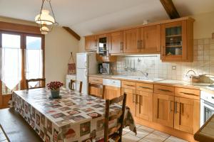 a kitchen with wooden cabinets and a table with a table cloth at Gîte Yveco in Châteauneuf