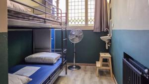 a room with two bunk beds and a fan at Hostel Cosmos Amsterdam in Amsterdam
