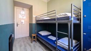a bunk bed room with two bunk beds and a door at Hostel Cosmos Amsterdam in Amsterdam