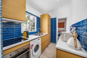 a kitchen with a washing machine and a sink at Blue Sardine Historic Townhouse Algarve Beaches in Portimão