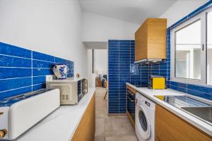 a blue tiled kitchen with a washing machine at Blue Sardine Historic Townhouse Algarve Beaches in Portimão +41 photos