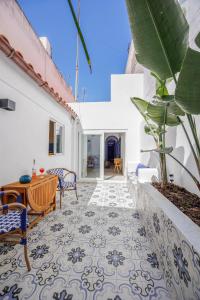 an outdoor patio with a table and chairs and a tile floor at Blue Sardine Historic Townhouse Algarve Beaches in Portimão