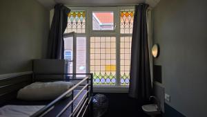a bedroom with a bed and a window at Hostel Cosmos Amsterdam in Amsterdam