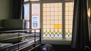 a room with a window and a bed in front at Hostel Cosmos Amsterdam in Amsterdam +48 photos
