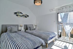 two beds sitting next to each other in a bedroom at Maison Les Flots De Port-mer in Cancale