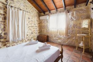 a bedroom with a bed in a room with stone walls at Siglo 16 Denia in Denia