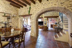 a living room with a table and a stone wall at Siglo 16 Denia in Denia