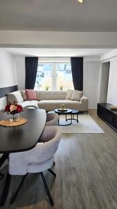 a living room with a couch and a table at Sauerland Apartments Willingen in Willingen