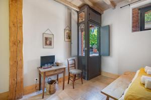 a bedroom with a desk with a computer and a bed at Maison d'hôtes de Gailhaguet in Verfeil