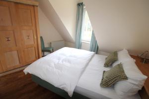 a bedroom with a bed with white sheets and pillows at Haus Kranich App 426 in Neuhaus