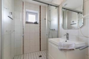 a white bathroom with a sink and a shower at Ferienwohnung Emilia in Garding +22 photos