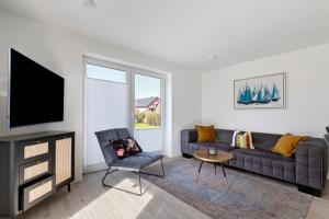 a living room with a couch and a tv at Ferienwohnung Emilia in Garding