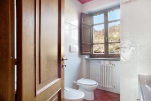 a bathroom with a toilet and a window at Casa della Barcareccia - per gruppi in Calice al Cornoviglio +22 photos