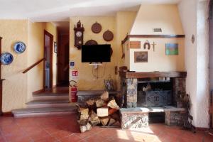 a living room with a fireplace and a tv at Casa della Barcareccia - per gruppi in Calice al Cornoviglio
