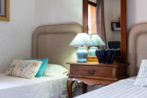 a bedroom with two beds and a lamp on a table at Cosy house jacuzzi wifi pool view in Mijas +19 photos