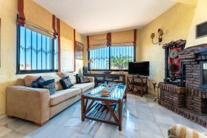a living room with a couch and a table at Cosy house jacuzzi wifi pool view in Mijas