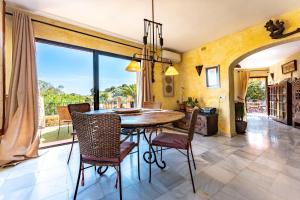 a dining room with a table and chairs and a large window at Cosy house jacuzzi wifi pool view in Mijas