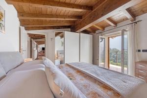 a bedroom with a large bed and a large window at Splendido loft panoramico in Veleso