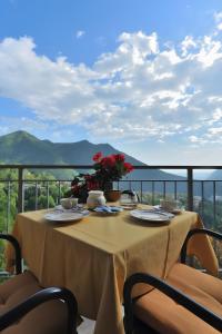 a table with flowers on top of a balcony at Splendido loft panoramico in Veleso