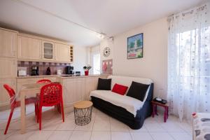 a living room with a table and a couch and a kitchen at Studio Montcalm in Aix-les-Bains
