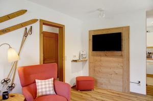 a living room with a red chair and a television at Ammerheimat in Oberammergau