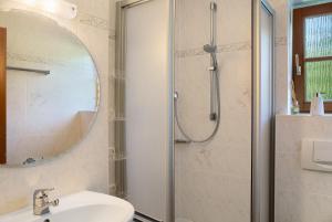 a bathroom with a shower and a sink and a mirror at Ammerheimat in Oberammergau +22 photos