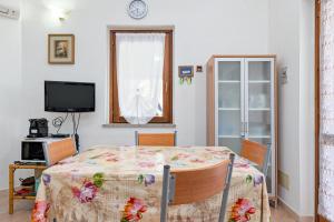 a dining room with a table and a television at Domus Dejana in San Teodoro