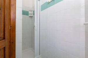 a bathroom with a shower with white tiles at Domus Dejana in San Teodoro +13 photos