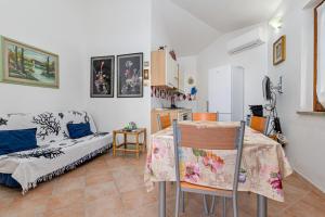a kitchen and living room with a table and a couch at Domus Dejana in San Teodoro