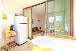 a kitchen with a white refrigerator in a room at Chez Colette d'en bas in Le Barcarès