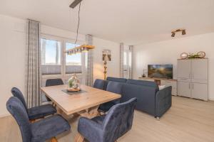 a living room with a table and a couch at FeWo Meerzeit Bernsteinquartier in Loddin