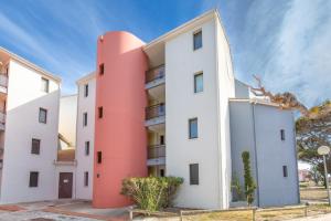 an apartment building with a pink at Chez Colette d'en bas in Le Barcarès