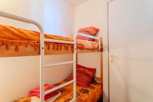 two bunk beds in a small room with a door at Chez Colette d'en bas in Le Barcarès +17 photos