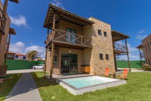 a house with a swimming pool in the yard at Beachfront Duplex #A6 - Aquiráz By Carpediem in Aquiraz