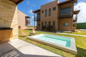 a swimming pool in the backyard of a house at Beachfront Duplex #A6 - Aquiráz By Carpediem in Aquiraz
