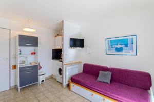 a living room with a purple couch in a room at Chez Colette d'en bas in Le Barcarès
