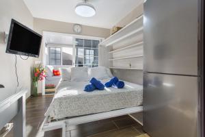 a bedroom with a bed with blue pillows on it at Sea and Sunset Love in San Marcos +20 photos