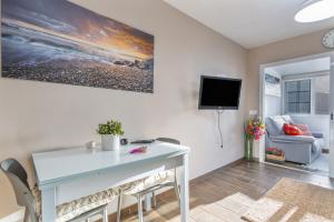a living room with a table and a tv on the wall at Sea and Sunset Love in San Marcos