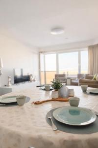 a table with a plate and fork and a living room at Anna's Haven, Knokke in Knokke-Heist