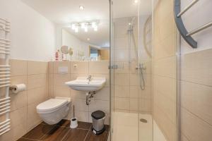 a bathroom with a toilet and a sink and a shower at Bungalow "Giny" in Bansin +14 photos